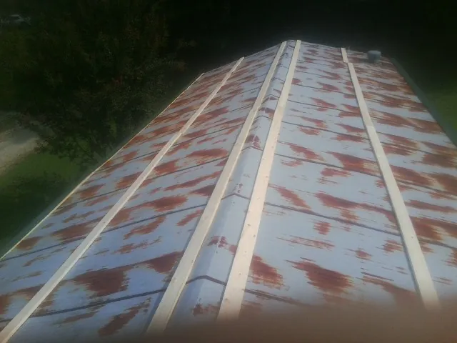 Rusted metal roof panels with new wood purlins before replacement — Storm Damage Roof Repair in Stewart by Roofing Brothers