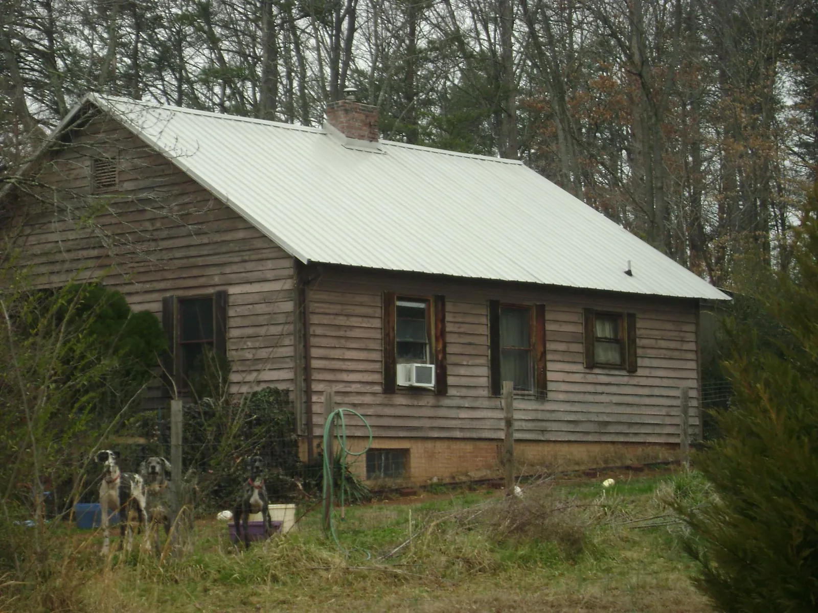 White metal roof on an old wood sided farmhouse, from a Metal Roof Installation job in Stewart